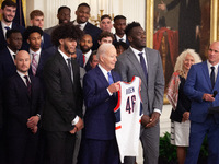 Members of the University of Connecticut men’s basketball team present President Joe Biden with a commemorative jersey during an event celeb...