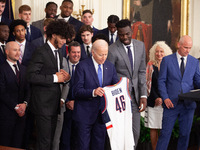 Members of the University of Connecticut men’s basketball team present President Joe Biden with a commemorative jersey during an event celeb...