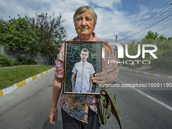 The grandmother of Sasha, 16 years old, in the portrait, marches along Dymer village claiming the release of his grandson and the captived c...