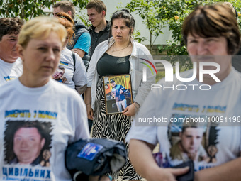 The mother of her captived son holds his portrait in a concentration of relatives of deported civilians of the ukrainian village Dymer to ru...