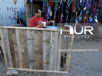 A Palestinian worker working in front of his shop in the Khan Younis refugee camp in the southern Gaza Strip on May 4, 2014. According to th...
