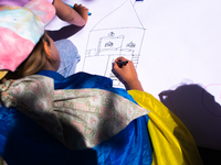 

A Ukrainian child is drawing a house during a demonstration and calling for the EU to save Ukrainian children in Dusseldorf, Germany, on J...