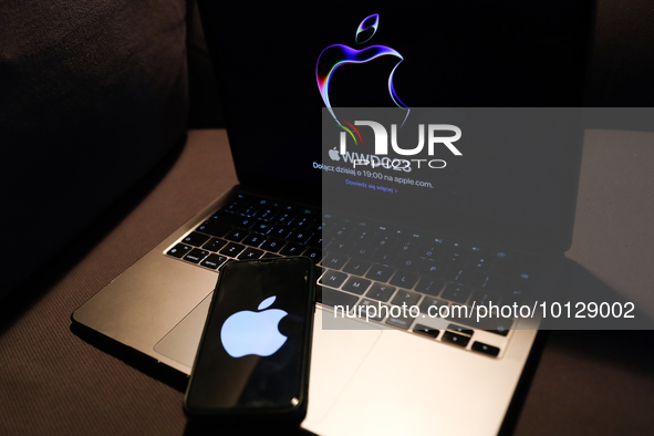 A laptop with Apple website displayed on a screen and Apple logo displayed on a phone screen are seen in this illustration photo taken in Kr...