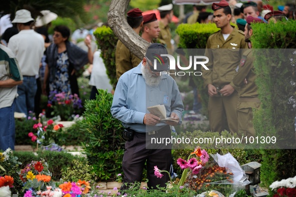 TEL AVIV, ISRAEL - MAY 05: An Israeli man prays by the grave of a fallen Israeli soldier at the military cemetery Kiryat Shaul on May 5, 201...