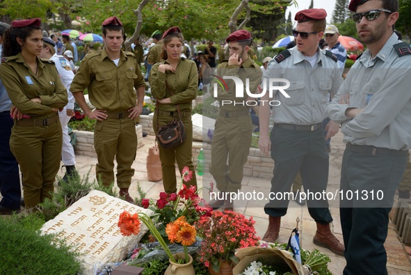 TEL AVIV, ISRAEL - MAY 05: Israeli soldiers stand by the grave of a fallen soldier at the military cemetery Kiryat Shaul on May 5, 2014 in T...