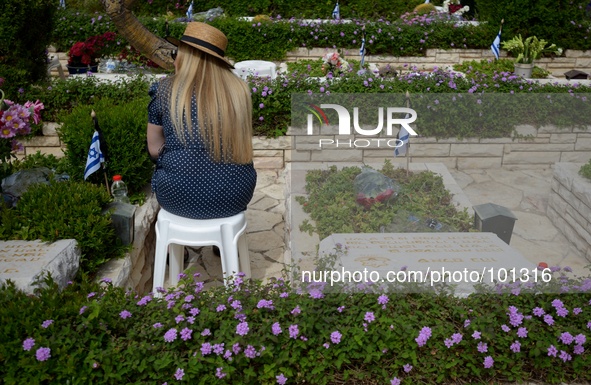 TEL AVIV, ISRAEL - MAY 05: An Israeli woman sits by the grave of a fallen Israeli soldier at the military cemetery Kiryat Shaul on May 5, 20...