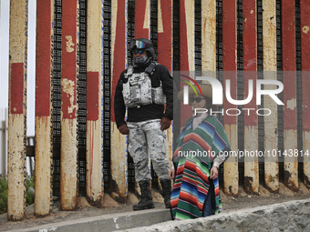 

A Chinese tourist is dressing in traditional Mexican costume as she poses with a member of Mexico's National Guard at the site of the US-M...