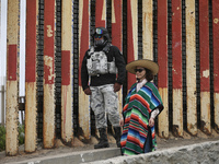 

A Chinese tourist is dressing in traditional Mexican costume as she poses with a member of Mexico's National Guard at the site of the US-M...