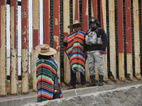 

Chinese tourists are dressing in traditional Mexican costume as they pose with a member of Mexico's National Guard at the site of the US-M...