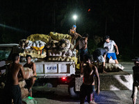 Workers load a truck with sacks of coconuts as the Mayon Volcano remains under alert level 3, in Legazpi, Albay province, Philippines, on Ju...