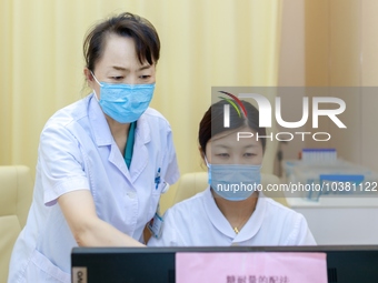 TENGZHOU, CHINA - AUGUST 17, 2023 - Geng Xingling, chief obstetrician, instructs a doctor to prescribe medicine in Tengzhou city, Shandong p...