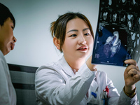 Cardiovascular physician Gu Yi shares the results of an imaging examination with a patient's family, August 18, 2023, Chongqing, China. Augu...