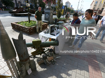 Ukrainians look at captured Russian weapons and remains of downed rockets displayed by the Ukrainian army on central capital's Khreshchatyk...