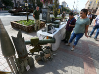 Ukrainians look at captured Russian weapons and remains of downed rockets displayed by the Ukrainian army on central capital's Khreshchatyk...