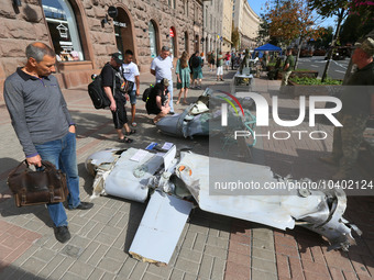 Ukrainians look at remains of downed Russian rockets displayed by the Ukrainian army on central capital's Khreshchatyk street ahead of Indep...