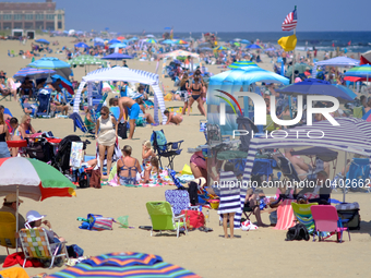 People flock the beach as thousands enjoy a summer day down the shore of the Atlantic Coast, near the seaside towns of Bradley Beach, Ocean...