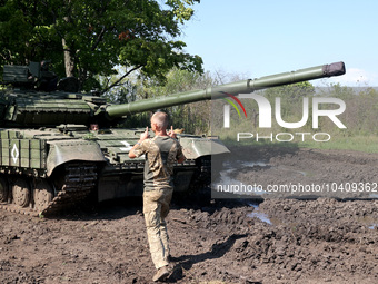 KHARKIV REGION, UKRAINE - AUGUST 16, 2023 - A serviceman stands before a tank as the military personnel of the 41st Separate Mechanized Brig...