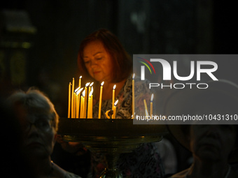 LVIV, UKRAINE - AUGUST 29, 2023 - A woman places a burning candle in memory of military personnel who perished during the breakthrough from...