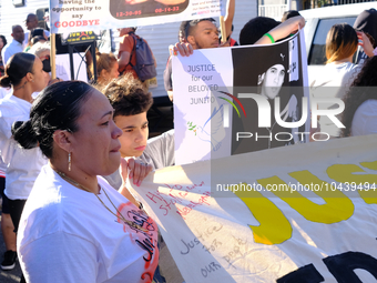 Family, community members and allies pause on Willard Street during a protest march demanding police accountability, to lay flowers at the l...