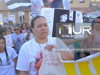 Family, community members and allies pause on Willard Street during a protest march demanding police accountability, to lay flowers at the l...