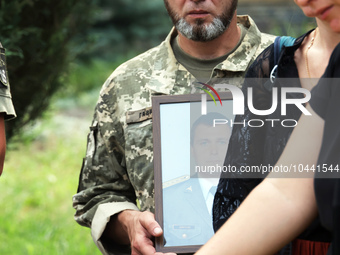 POLTAVA, UKRAINE - SEPTEMBER 1, 2023 - A serviceman holds a portrait during a funeral ceremony of pilots and technicians of two Mi-8 helicop...