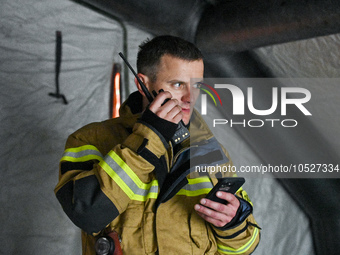 LVIV, UKRAINE - SEPTEMBER 19, 2023 - A State Emergency Service employee communicates over a handheld transceiver during a response effort to...
