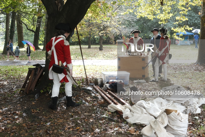 Historic reenactors in British Red Coats and Continental Blue Coats attire pause during a sudden downpour as the Revolutionary Germantown Fe...