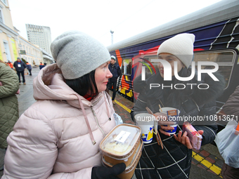 Local residents are receiving containers with food cooked on the Food Train at the railway station in Kharkiv, northeastern Ukraine, on Nove...