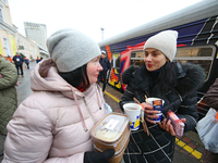Local residents are receiving containers with food cooked on the Food Train at the railway station in Kharkiv, northeastern Ukraine, on Nove...