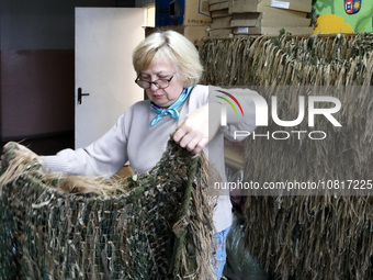 Nadiia Lystopad, the founder of the Combat Toloka Volunteer Centre, is showing a ghillie suit made by volunteers for the Ukrainian military...