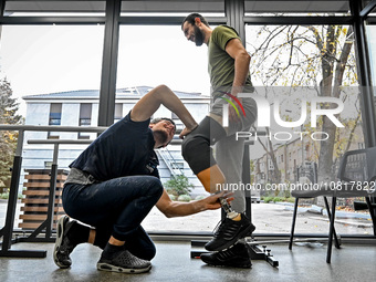 A prosthetist, Oleksii Yatsenko (L), is helping serviceman Andrii with the fitting of a prosthetic leg at the Prosthetics and Rehabilitation...