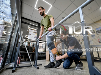 Prosthetist Oleksii Yatsenko (R) is helping serviceman Andrii with the fitting of a prosthetic leg at the Prosthetics and Rehabilitation Cen...