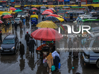 People are walking amid rainfall at the Bus Stand in Sopore District, Baramulla, Jammu and Kashmir, India, on November 30, 2023. (