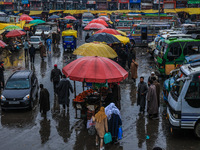 People are walking amid rainfall at the Bus Stand in Sopore District, Baramulla, Jammu and Kashmir, India, on November 30, 2023. (