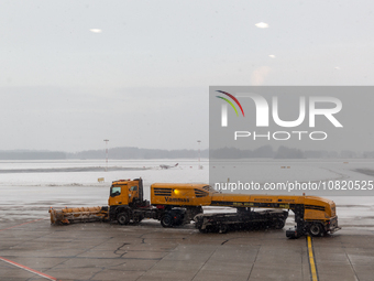 Trucks in the morning clear snow which fell in the night  from the airport runways in Katowice-Pyrzowice Airport, Poland on November 30, 202...
