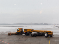 Trucks in the morning clear snow which fell in the night  from the airport runways in Katowice-Pyrzowice Airport, Poland on November 30, 202...