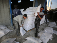 Palestinians are receiving bags of flour for humanitarian aid distribution in Bureij camp in the central Gaza Strip on November 30, 2023. Tr...