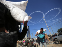 Palestinians are receiving bags of flour for humanitarian aid distribution in Bureij camp in the central Gaza Strip on November 30, 2023. Tr...