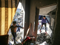Palestinians are inside their damaged home in Bureij camp in the central Gaza Strip on November 30, 2023, amid a truce in fighting between I...