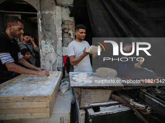 Palestinian workers are making bread in a different location near the former spot of Al-Maghazi bakery, which was heavily damaged in an Isra...