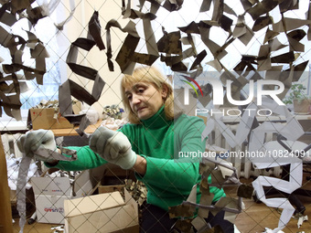 A volunteer at the Combat Toloka Volunteer Centre is making a camouflage net for the Ukrainian military in Kriukivshchyna, Kyiv Region, Nort...
