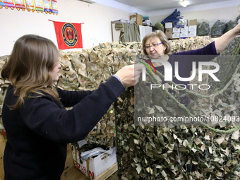 Volunteers at the Combat Toloka Volunteer Centre are displaying a camouflage net they have created for the Ukrainian military in Kriukivshch...