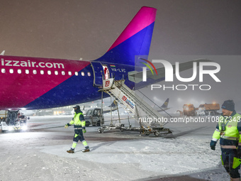 Passengers disembark a plane after flight delay due to heavy snow at Krakow Airport in Balice, Poland on December 2rd, 2023. Intense snowfal...
