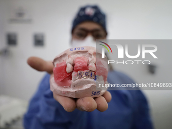 A dentist is holding a dental impression inside the Centro de Odontogeriatria Centro de Salud TIII Doctor Guillermo Roman y Carrillo in the...