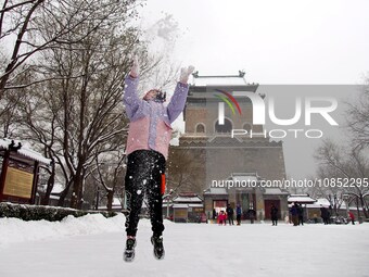 Tourists are playing in the snow at the Bell and Drum Tower Square in Beijing, China, on December 14, 2023. (