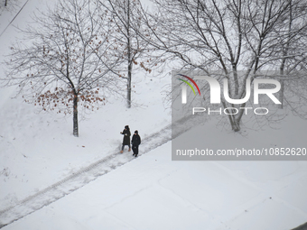 People are walking down the street during a snowfall in Kyiv, Ukraine, on December 14, 2023. (