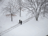 People are walking down the street during a snowfall in Kyiv, Ukraine, on December 14, 2023. (