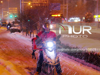A courier is braving the snow to make a delivery in Beijing, China, on December 14, 2023. (