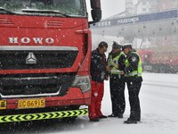 Traffic police are on duty in the snow in Handan, Hebei Province, China, on December 14, 2023. (