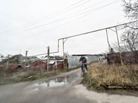 A man is riding a bicycle on a washed-out dirt road in the frontline Orikhiv, Zaporizhzhia Region, southeastern Ukraine, on December 13, 202...